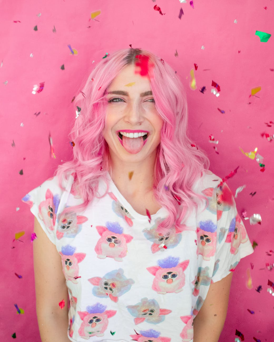 woman showing hear tongue while leaning on wall