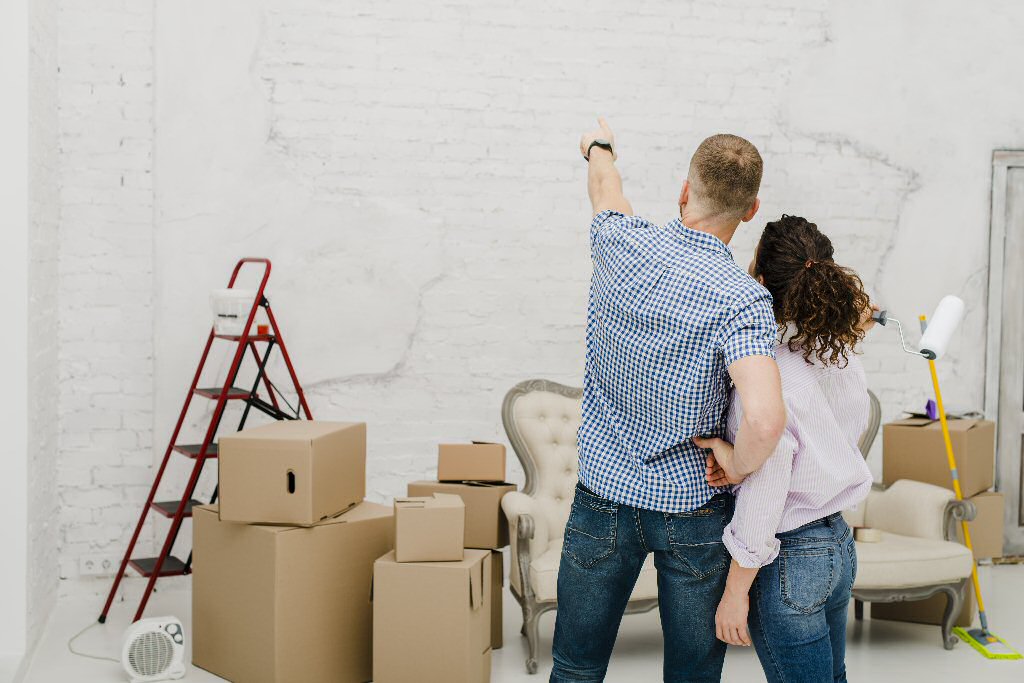 man pointing at wall with woman