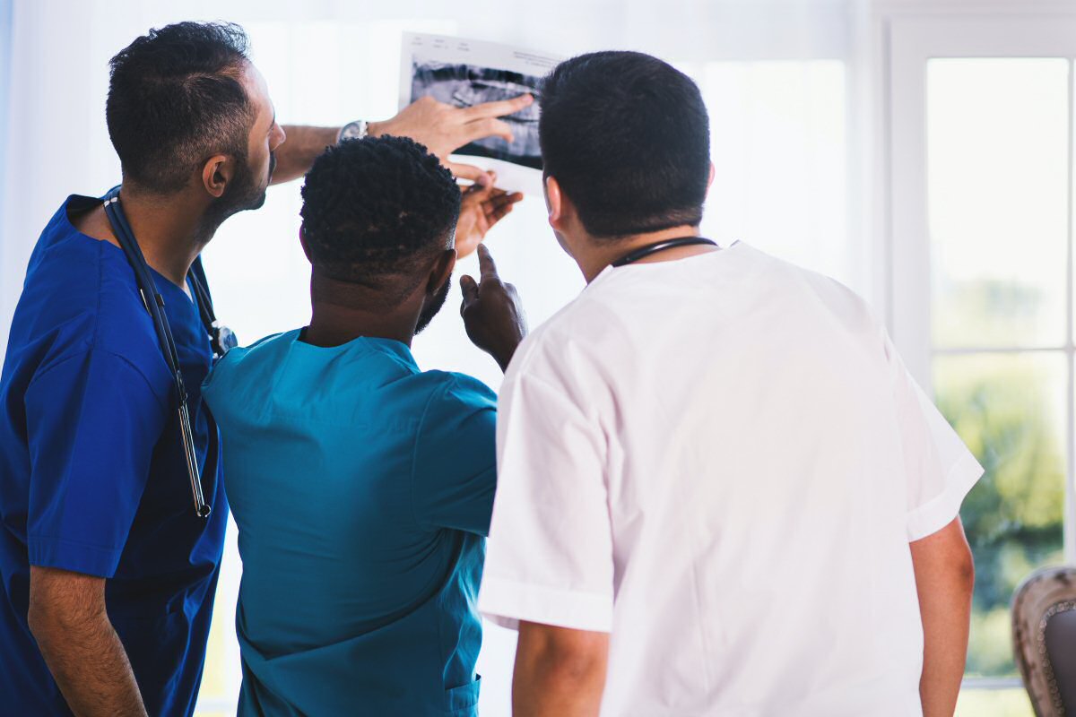 three doctors looking at xray