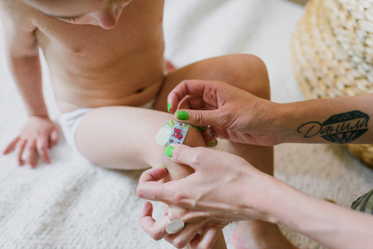 mom applying band aid to child