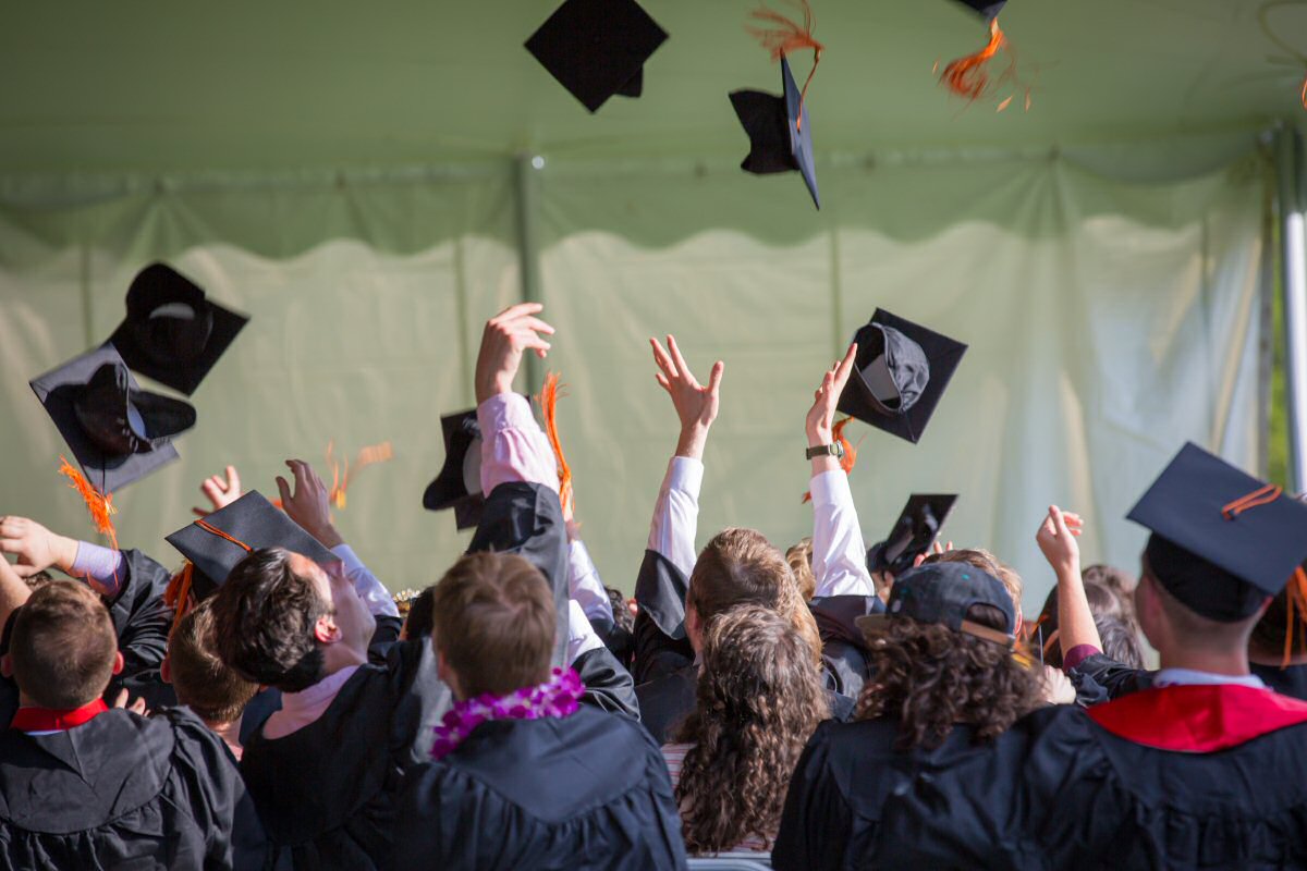 graduates throwing caps in air