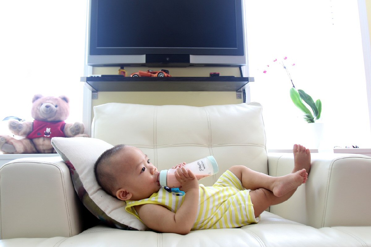 baby drinking bottle on couch